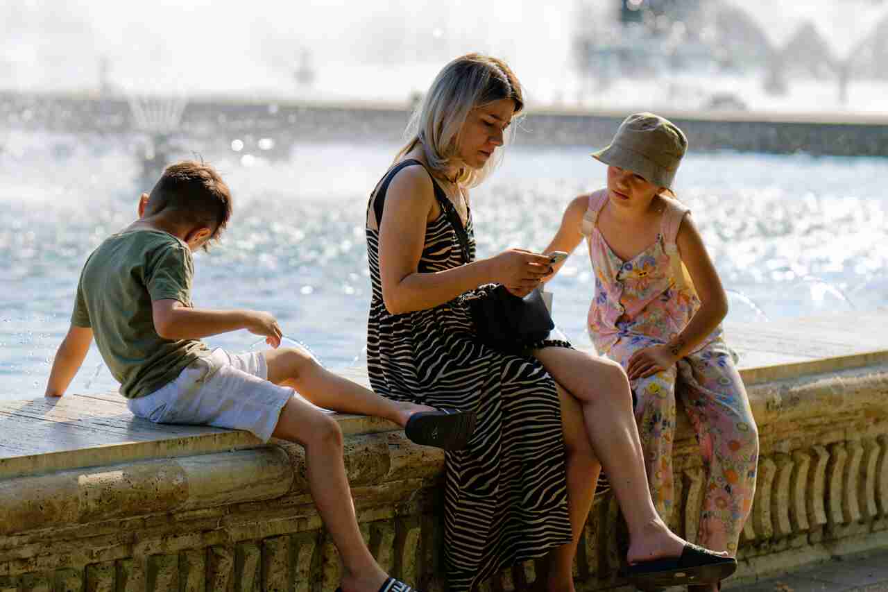 Kobieta siedząca z dwójką dzieci